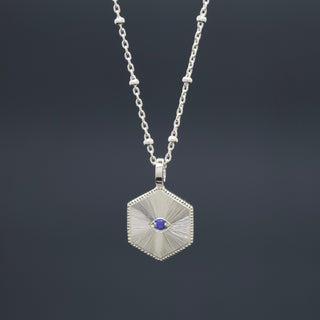 Silver hexagon pendant necklace with blue gemstone and radiant fan design