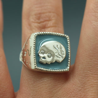 Silver signet ring, square bezel with engraved skull motif and stone border
