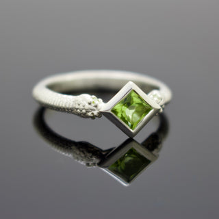 Silver snake band ring with square green gemstone and small side green stones