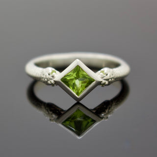Silver snake band ring with square green center stone and side gemstone details