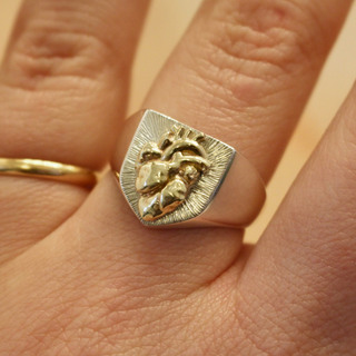 Silver shield signet ring with a solid gold anatomical heart centre, hand engraved with a bright-cut halo and a thick tapered band, handcrafted by Emily Proudfoot Jewellery