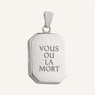 Silver locket pendant with engraved latin motto text 'VOUS OU LA MORT' on a white background