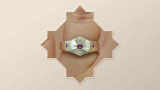 A silver  hexagon signet ring with a central natural pink round sapphire gemstone and smaller side sapphire gemstones set in decorative 4 point star settings. The face of the ring is finished with a bright cut hand engraved Guilloché  sunray pattern. Perfect alternative engagement or wedding ring - Emily Proudfoot 