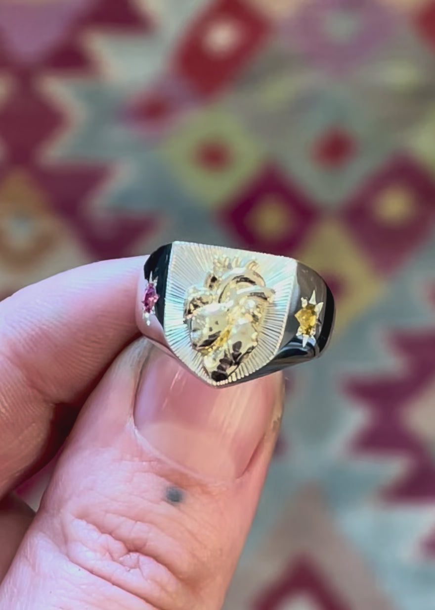 Silver heraldry shield shaped signet ring with anatomical gold human heart and guilloché bright cut sunray engraving on the face. The ring band is 8 point star set with pink spinel and citrine - Emily Proudfoot - Hand Engraver 