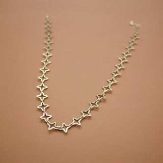 Yellow-gold star-link choker chain with repeating star shapes along the curve.